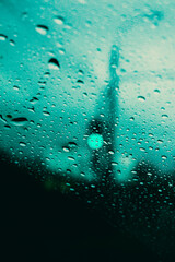 parabrisas con gotas de lluvia con luz de semáforo desenfocado en día nublado