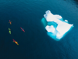 Kayak on the sea in Greenland next to big icebergs close to Ilulissat icefiord, aerial view