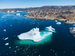Aerial view of Ilulissat town during summer and sea full of icebergs in greenland