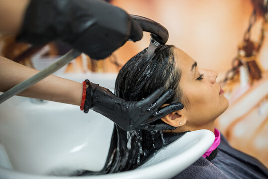 female client washes hair in salon, professional hairdresser washes head of female client with water and shampoo treatment, hairstyle beauty hair car?