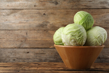 Ripe white cabbage on wooden table. Space for text