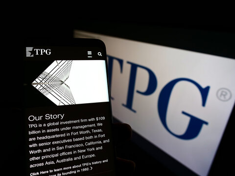 Stuttgart, Germany - 12-18-2021: Person holding cellphone with website of US investment company TPG Capital on screen in front of business logo. Focus on center of phone display.
