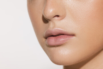 Fototapeta premium Closeup female lips, cheeks and nose isolated over white studio background. Concept of cosmetology, skincare, cosmetics, plastic surgery, ad