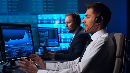 Team of brokers is working in office using workstation and analysis technology. Workplace of professional traders. Global financial markets, business strategy, currency exchange and banking.