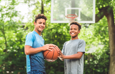 two teens in sportswear playing basketball game