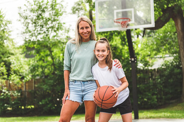 Obraz premium Mother and little daughter play basketball outside