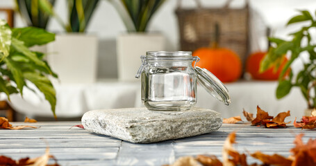 Autumn composition on a wooden table surrounded by green leaves and empty space