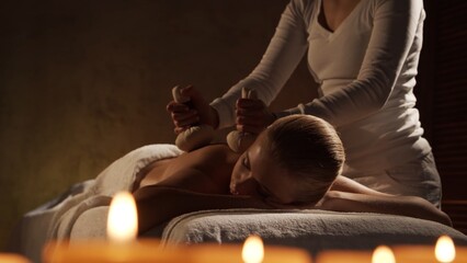 Young, healthy and beautiful woman gets massage therapy in the spa salon. Healthy lifestyle and...