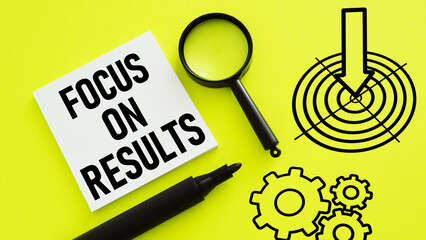 Focus on results is shown using the text and picture of aim and photo of magnifying glass