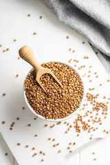 Uncooked buckwheat grain in bowl.