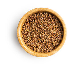 Uncooked buckwheat grain in scoop isolated on white background.