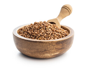 Uncooked buckwheat grain in scoop isolated on white background.
