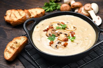 Mushroom soup with bread and fresh mushrooms on a wooden background , autumn seasonal cream soup with vegetables 