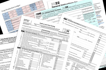2022 IRS farming tax forms and simulated crop report lay on a desk top. - obrazy, fototapety, plakaty