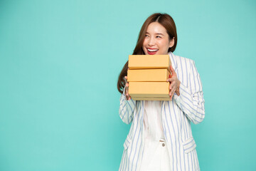 Happy Asian woman holding package parcel box isolated on green background, Delivery courier and shipping service concept