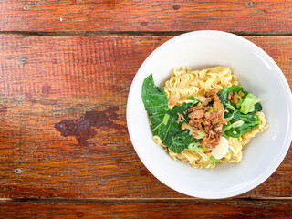 unstirred instant noodles with vegetable and fried onion as topping. Copy-space.