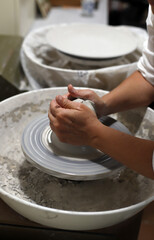 manos de artesana moldeando cerámica en horno de alfarero artesanal - obrazy, fototapety, plakaty