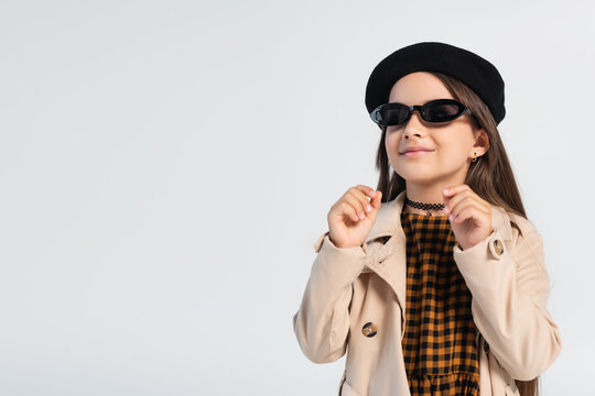 Happy Girl In Stylish Trench Coat And Sunglasses Smiling Isolated On Grey.