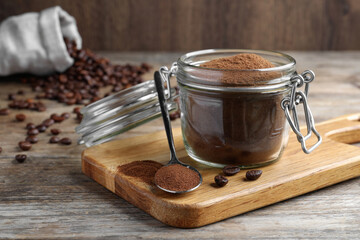 Glass jar of instant coffee and spoon on wooden table