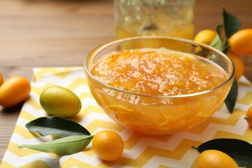 Delicious kumquat jam in bowl and fresh fruits on table, space for text - obrazy, fototapety, plakaty