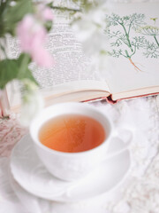 Obraz na płótnie Canvas A white cup of tea to an open book