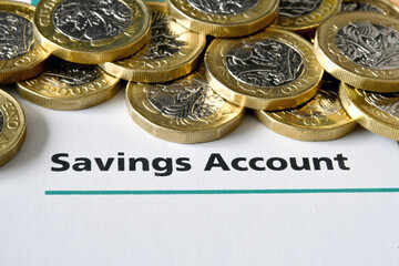 British one pound coins on top of the cover of a savings book. No people.