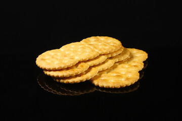 Oval crackers on a black table with reflection. Close-up
