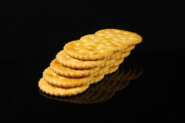 Oval crackers on a black table with reflection. Close-up