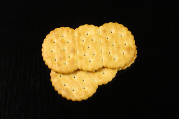 Oval crackers on a black table with reflection. Close-up