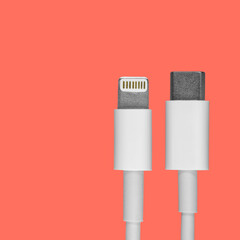 Data usb lightning cable lugs for a smartphone on a coral background, a mockup of an advertising...