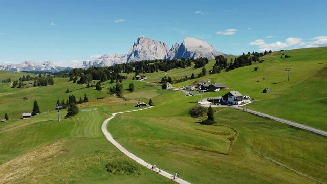 Seiser Alm Alpe di Siusi and Chalet in Dolomites near Compatsch, Compaccio Italy. Sassolungo and Sassopiatto mountai range, Langkofel and Plattkofel aerial view. South Tyrol Trentino Alto Adige, Italy