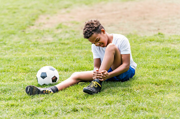 hispanic soccer player outdoor in sunny day having ankle injury