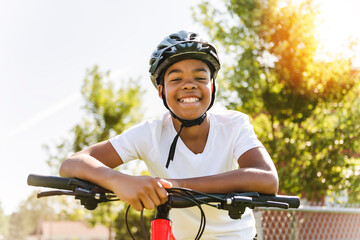boy riding bike wearing a helmet outside - Powered by Adobe