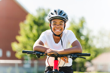 boy riding bike wearing a helmet outside - Powered by Adobe