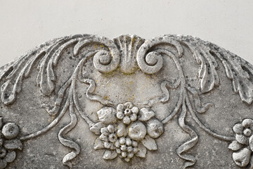 Detail of the floral decor of an Italian facade with stone and stucco decoration
