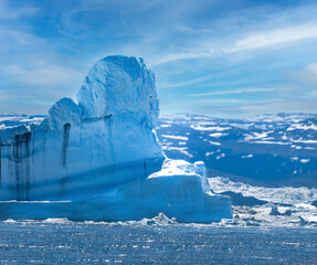 Enormous icebergs with sculptural forms of great beauty crowding the waters of the Disko Bay north...