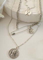 Fashion jewelry - silver triple chain with medallions on a white stand
