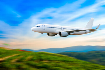 Naklejka na ściany i meble Commercial airplane above in summer season and blue sky over beautiful scenery nature background,concept business travel and transportation summer vacation travel.