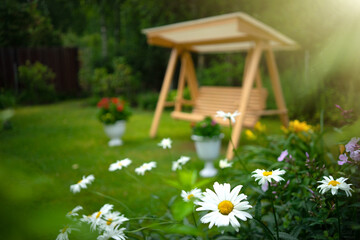 Artistically blurred photo with a swing in the garden in a green clearing. Defocus for the...