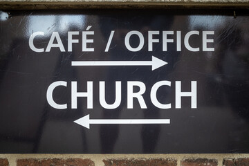 Copenhagen, Denmark, A sign showing the way to a cafe an office and a church.