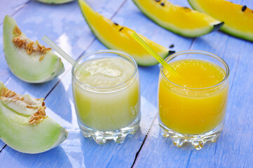Healthy melon and watermelon smoothie on a wooden table.
