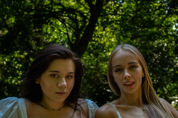 Fototapeta premium two girlfriends blonde and brunette are walking in the park