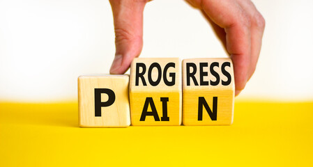 Pain or progress symbol. Concept words Pain or Progress on wooden cubes. Businessman hand. Beautiful yellow table white background. Business and pain or progress concept. Copy space.