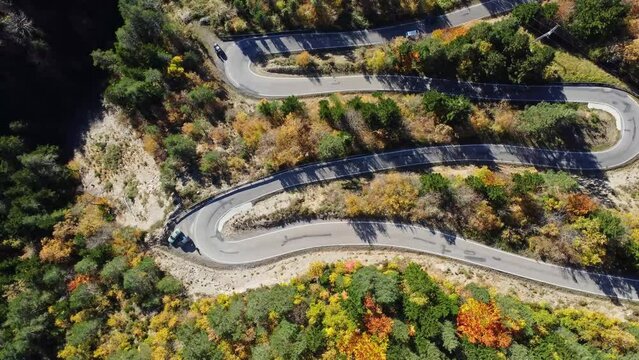 Amazing drone view of roadway in mountains covered with lush autumn foliage