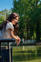 Naklejka premium A beautiful girl in a white dress by the lake