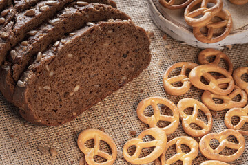 pretzels and pieces of dark whole grain bread on a fabric surface