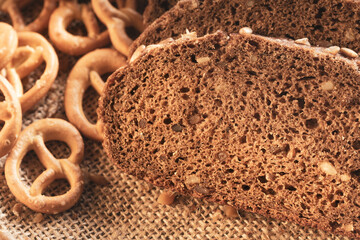 pieces of whole grain bread on a fabric background and golden pretzel