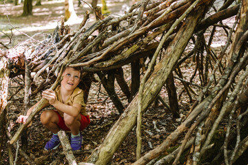 Boy building shelter from sticks