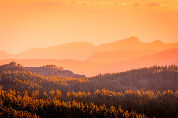Amazing bright sunset over rocky cloudy mountains