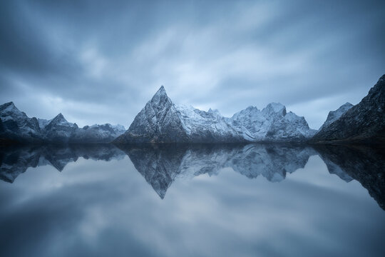 Rocky mountain ridge and wavy sea against gloomy sky in Norway - Powered by Adobe